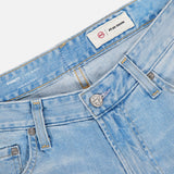Close-up of the waistband and front of AG's Everett Jeans in 22 Years, a vintage-inspired slim fit style in light blue with belt loops, metal button, zipper, and two inside waistband labels including one reading A.B-D DENIM.