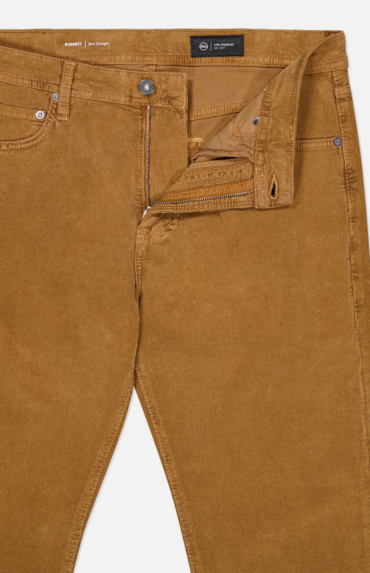 A pair of Everett Corduroy Pant in Bronze by AG, featuring a slim fit and a subtle bronze corduroy fabric, shown with the fly unzipped and button undone to reveal the waistband and part of the front pockets.