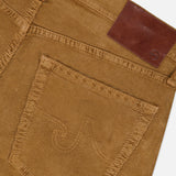Close-up of the back pocket of the AG Everett Corduroy Pant in Bronze, featuring a stitched design and a brown leather patch above the pocket, highlighting its distinctive bronze hue.