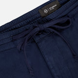 Close-up of AG Oliver Drawstring Shorts in navy blue, featuring a comfortable mid rise, elastic waistband with drawstring, and visible AG brand label. Fabric appears to be cotton or a cotton blend.