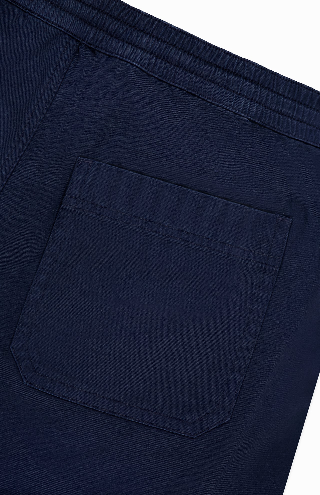 Close-up of the back pocket on AG's Oliver Drawstring Shorts in navy, showcasing the elastic waist, intricate stitching, and textured fabric.