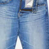 A pair of AG Protege Jean in 14 Years, shown from above with the zipper partially unzipped and the button fastened. These straight leg jeans feature a faded wash, classic five-pocket styling, and vintage detail for timeless appeal.