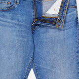 The AG Protege Straight Leg Jeans in Promise are light blue, comfortable stretch denim with classic yellow stitching, a partially open fly showing the zipper and button, visible inner waistband, and a front pocket rivet.