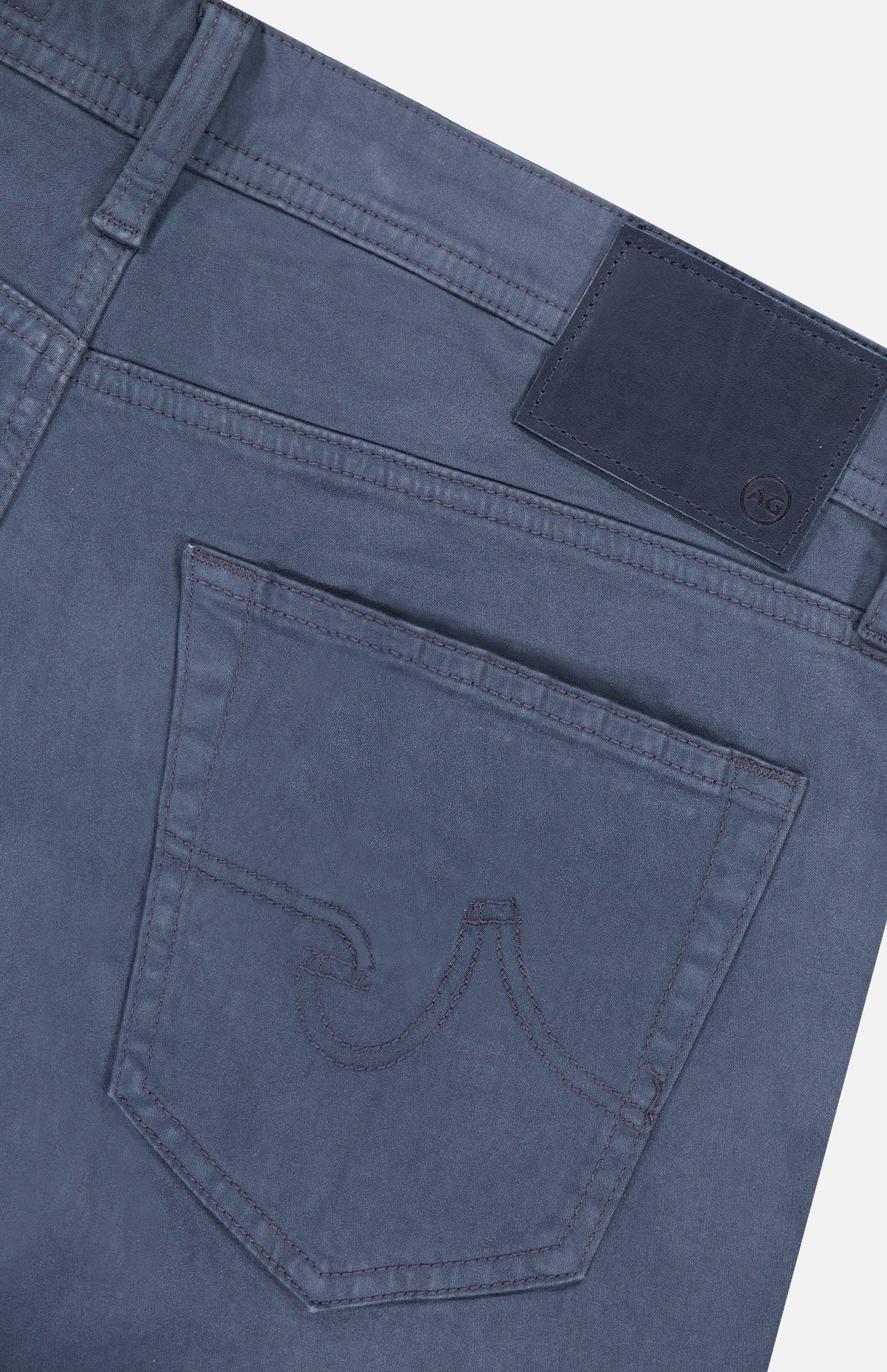 Close-up of the back of AG Tellis Sueded Sateen Pants in Blue Grain, showing a single back pocket with decorative stitching and a dark rectangular patch on the waistband.