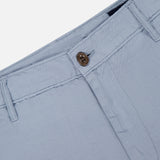 Close-up of the waist and upper section of AG's Wanderer 8.5" Inseam Shorts in light blue, featuring the waistband, belt loops, button closure, and part of the zipper fly against a plain background.