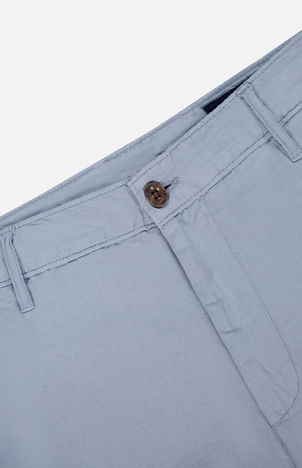 Close-up of the waist and upper section of AG's Wanderer 8.5" Inseam Shorts in light blue, featuring the waistband, belt loops, button closure, and part of the zipper fly against a plain background.