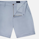The AG Wanderer 8.5" Inseam Shorts for men in light blue feature a slim fit, front side pockets, belt loops, and a partially open button and zip fly, shown laid flat on a white background.