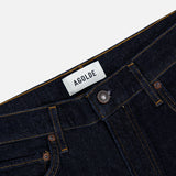 Close-up of the waistband and upper section of the Harper Jean in Reissue by AGOLDE in dark indigo, featuring yellow stitching and a white AGOLDE label, highlighting the signature details of these relaxed mid-rise jeans.