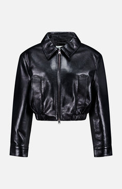 The AGOLDE Nahla Cropped Jacket, a black leather piece with a wide collar, front zipper, long sleeves, and two vertical front pockets, is shown against a plain light gray background.