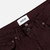 Close-up of the waistband and top of a pair of AGOLDE Ren Jean in Sloe Berry high-rise jeans, showing the brand label, button, zipper, belt loops, and pockets on a white background.