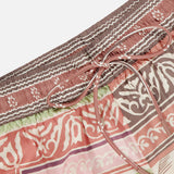 Close-up of the Alberta Silk Pull-on Pant by ALEMAIS, featuring a relaxed fit, elastic waistband with drawstring, and bohemian motifs in pink, brown, green, and white.