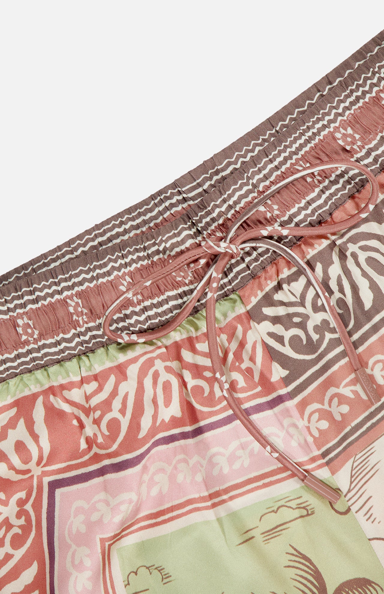 Close-up of the Alberta Silk Pull-on Pant by ALEMAIS, featuring a relaxed fit, elastic waistband with drawstring, and bohemian motifs in pink, brown, green, and white.