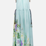 The Alfie Sleeveless Midi Dress by ALEMAIS is a light blue cotton dress with drawstring ties at the shoulders and waist, a floral-print hem in green, purple, and white, and brown-and-white striped trim at the bottom.