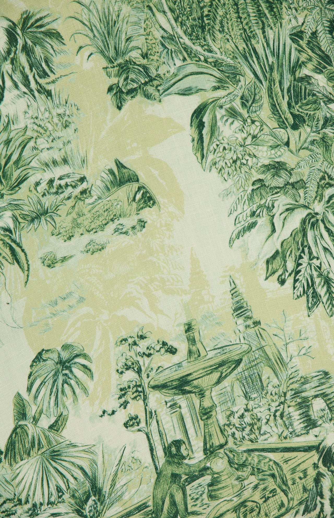A vibrant green and yellow illustration of tropical plants, a fountain, and a monkey inspires the Sara Mini Twist Sundress by ALEMAIS—an ideal choice for those seeking lush, exotic style with bold foliage prints.