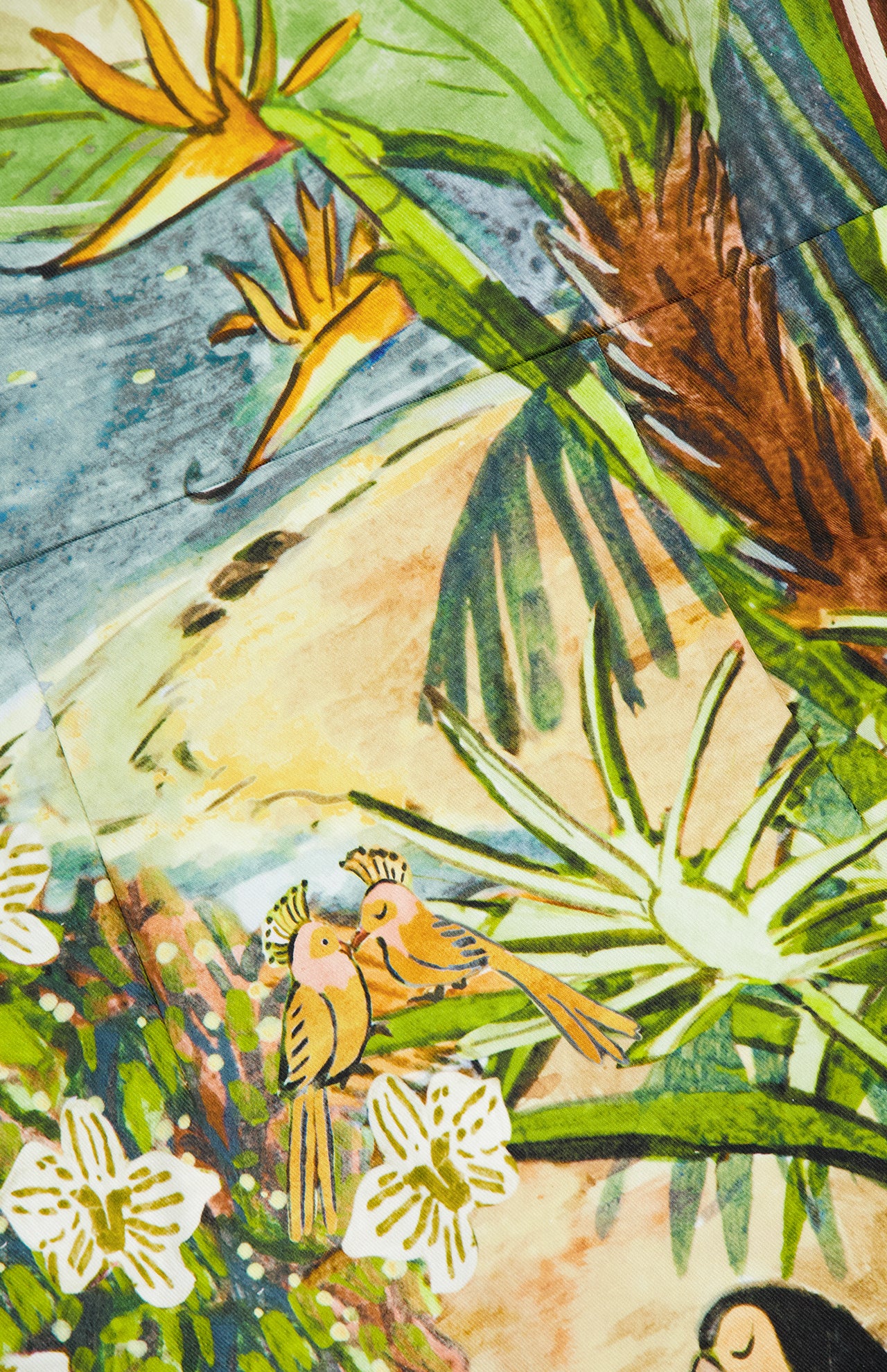 A vibrant illustration of two orange tropical birds on lush green foliage and white flowers inspires the Toucan Tango Halter Mini Dress by ALEMAIS, evoking resort style with a breezy feel against a soft sandy backdrop.