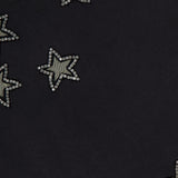 Close-up of ALICE + OLIVIA's Cindy Cropped T-shirt, featuring crystal star cutouts—an eye-catching black top, perfect for a women's night out.