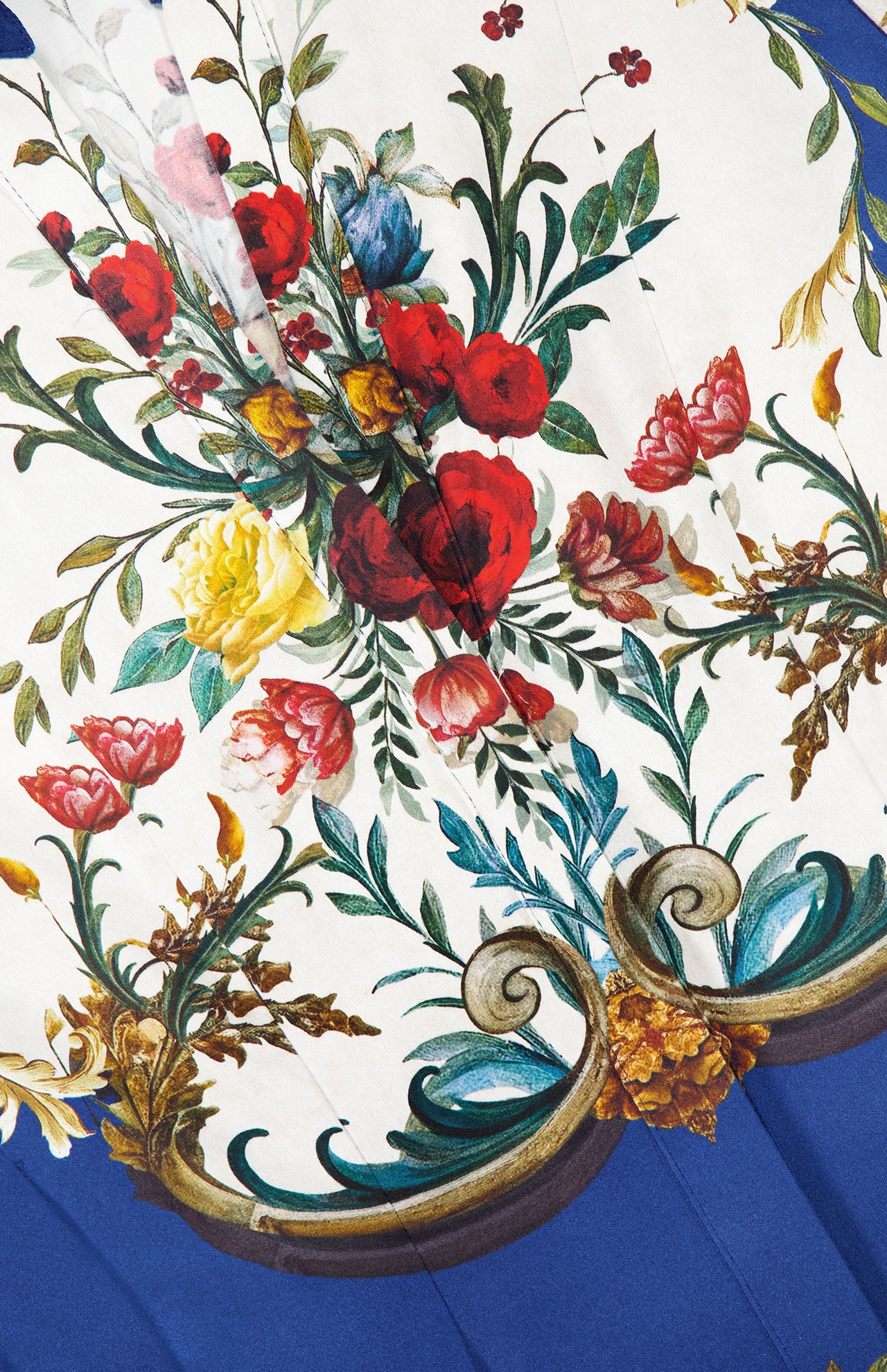 The Lucy Short Sleeve Mini Shirt Dress With Tie Belt by ALICE + OLIVIA features a detailed floral pattern in red, pink, yellow, and blue with green leaves and golden scrollwork on white, finished with a blue border.