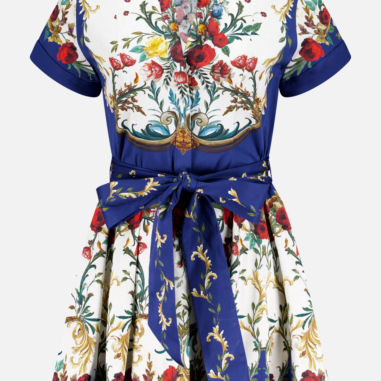 The Lucy Short Sleeve Mini Shirt Dress With Tie Belt by ALICE + OLIVIA features a deep V-neck, red, yellow, and green floral print on white, blue borders, short sleeves, and a wide blue sash at the waist.