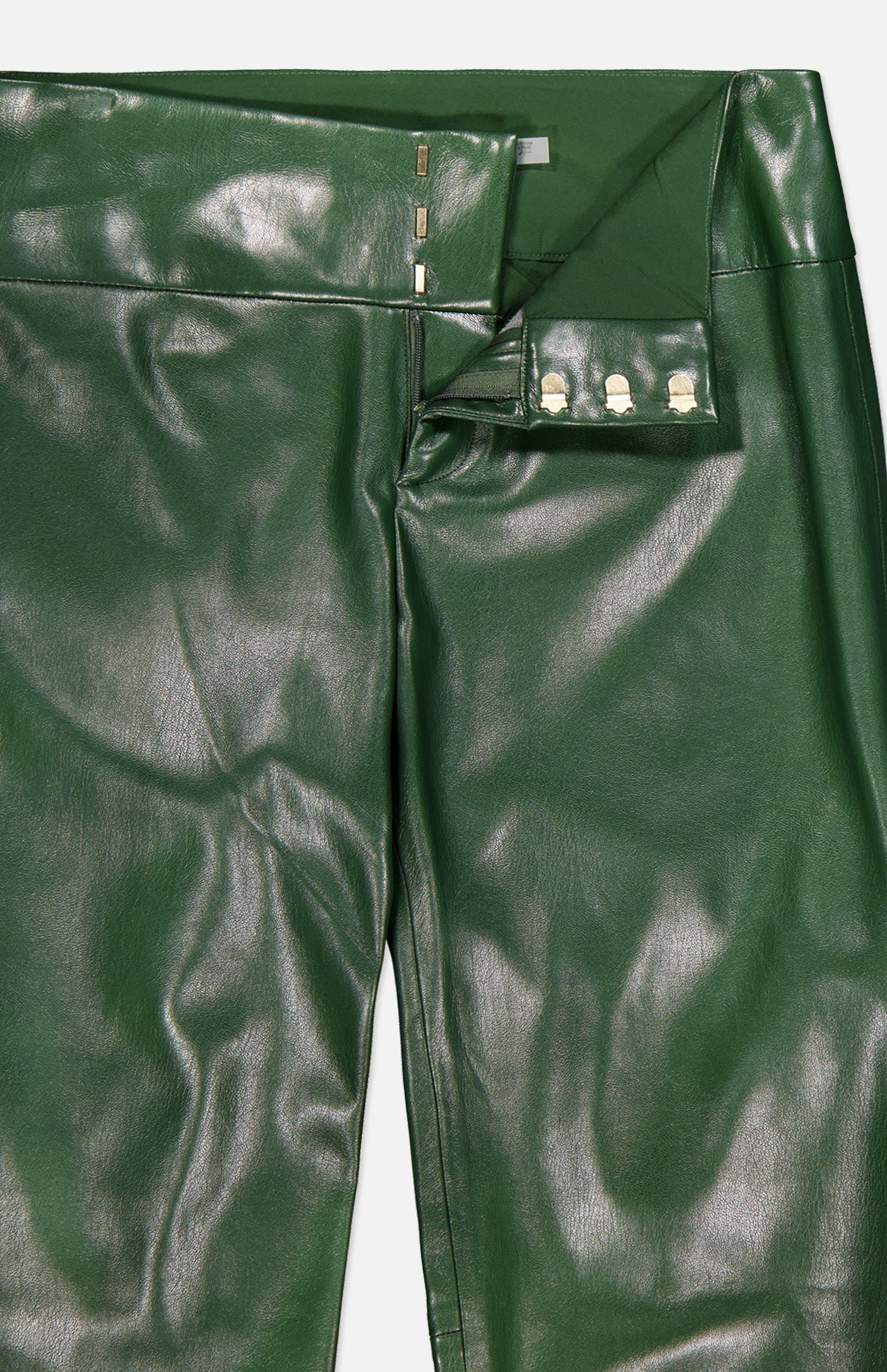 Close-up of the ALICE + OLIVIA Olivia Vegan Leather Fit Flare Pant in dark olive, featuring shiny vegan leather, silver snap buttons, a partially open waistband, and smooth fit-and-flare material.