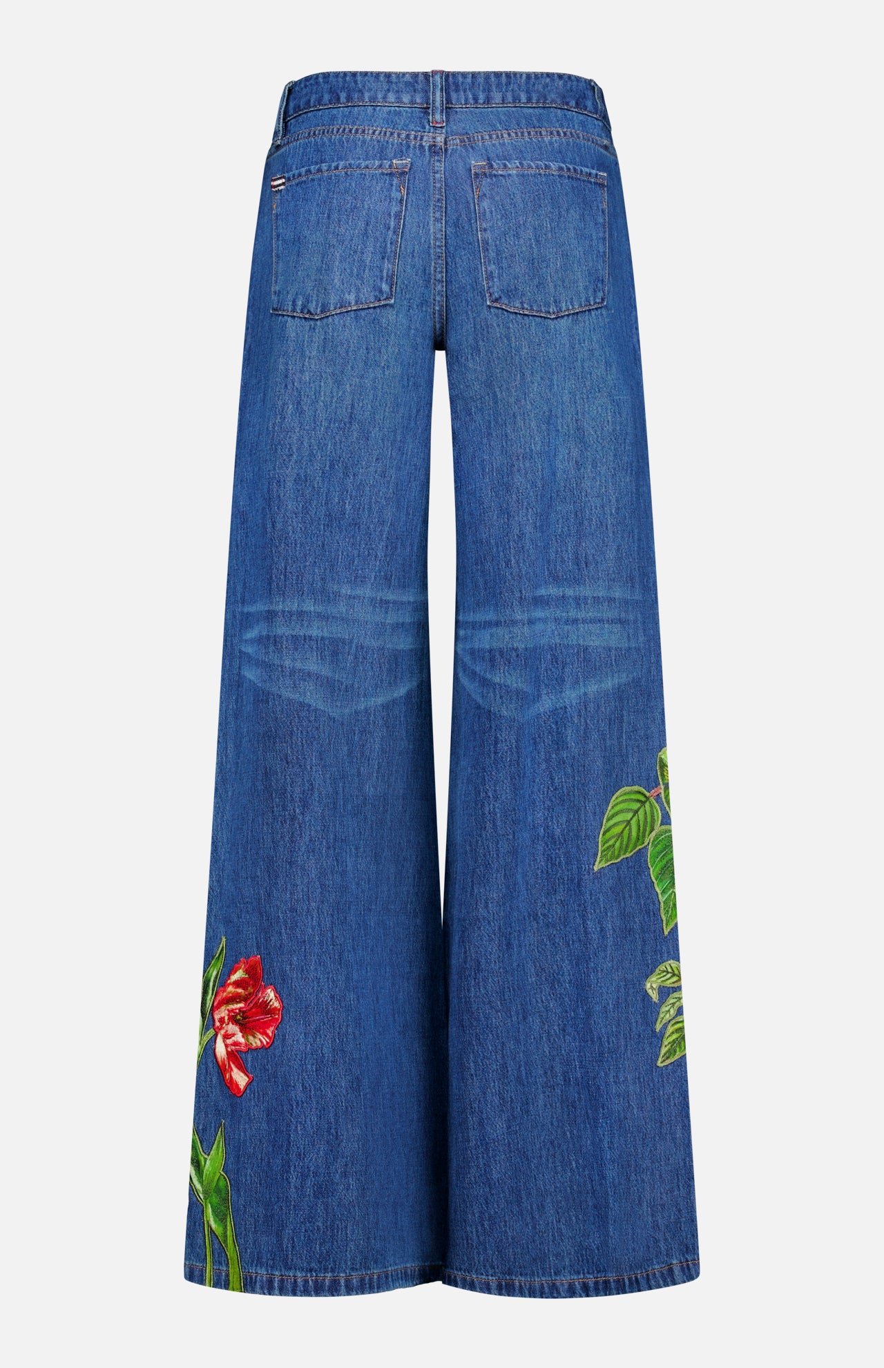 Discover the ALICE + OLIVIA Low Rise Baggy Jean with Applique in Freyja—a wide-leg, dark wash jean featuring back pockets and vibrant embroidered floral and green leaf appliques near the hems of both legs. The relaxed, baggy silhouette is finished with faded detailing at the back of the knees.