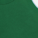 Close-up of the Araceli Two Tone Tank Top by ALICE + OLIVIA, a green sleeveless cropped top with a ribbed neckline and light blue armhole trim. The partially visible label near the top edge shows the designer brand.