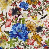 Close-up of the Carson Floral Printed Cardigan by ALICE + OLIVIA, showcasing a vibrant floral-patterned fabric with bold blue, yellow, red, and pink blossoms. Sparkling gold buttons are sewn onto the intricate design, adding eye-catching accents—perfect details for this vintage-inspired cropped cardigan that brightens up any fall florals look.