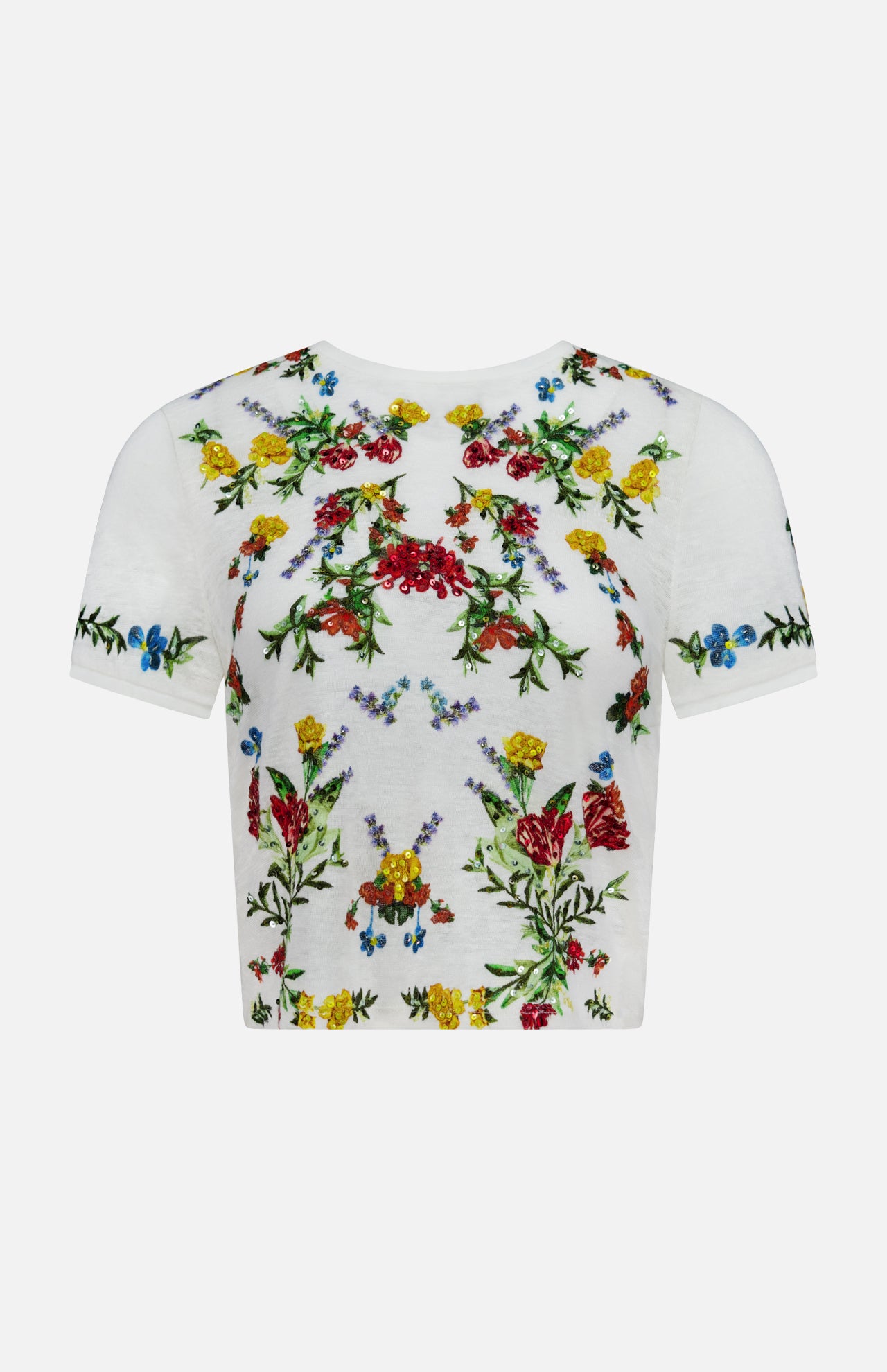 The Cindy Embroidered Cropped T-shirt by ALICE + OLIVIA is a white tee adorned with vibrant floral embroidery in red, yellow, blue, and green across the front, sleeves, and neckline. Delicate floral design details and sparkling sequin embellishments add a touch of shimmer. The t-shirt is displayed against a plain white background.