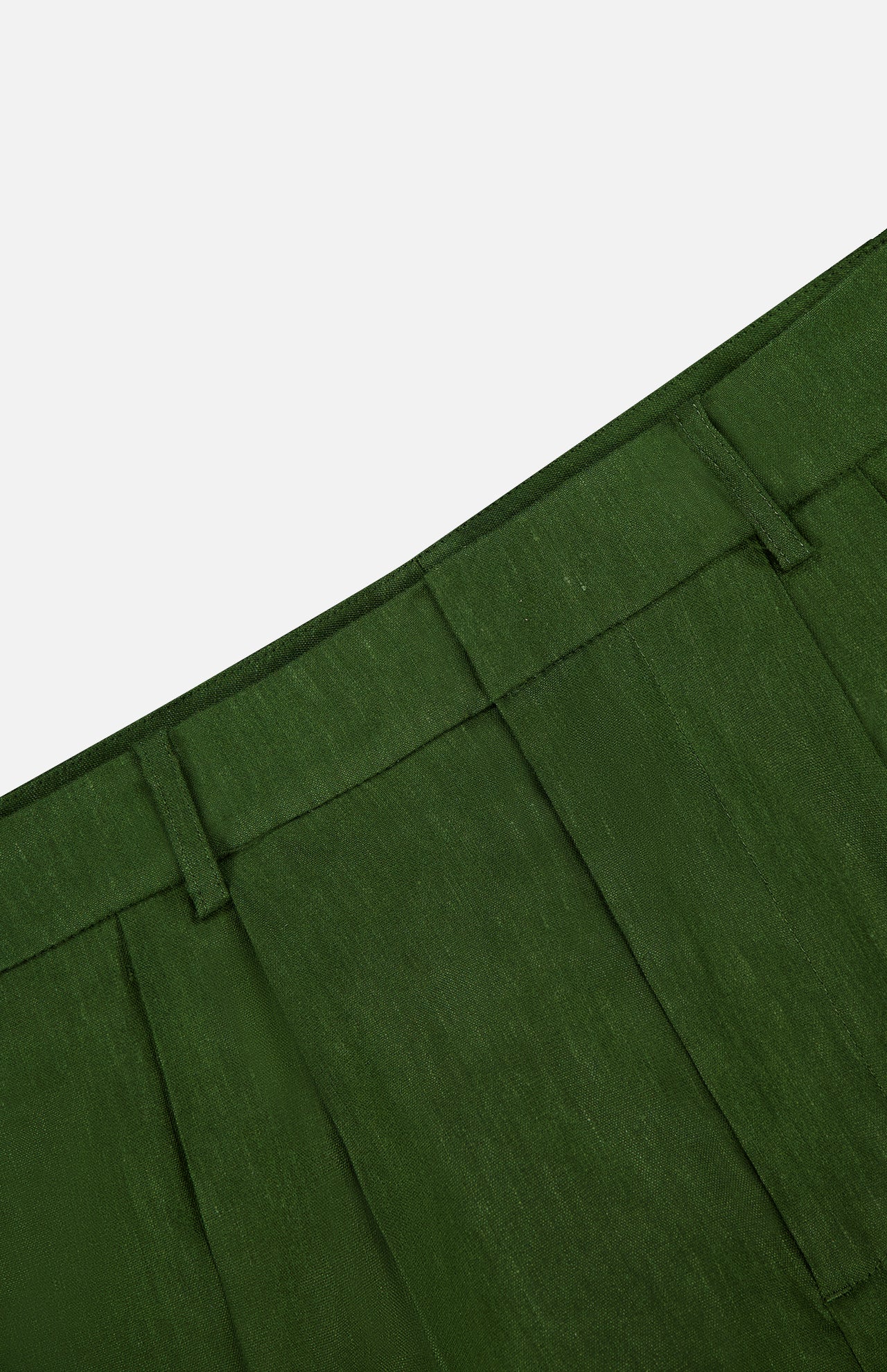 Close-up of the waistband and pleats of the Conry Relaxed Long Pleated Short by ALICE + OLIVIA in dark green, featuring belt loops and linen fabric texture against a white background. The image showcases the relaxed fit and classic detailing that define these pleated shorts.