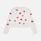 The ALICE + OLIVIA Daroda Lip Cardigan Sweater is a white cropped knit, detailed with red embroidered lips scattered across the back and sleeves.
