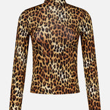 The Delania Long Sleeve Turtleneck Top by ALICE + OLIVIA features a form-fitting, sheer silhouette with an all-over leopard print in brown, black, and gold tones. Crafted from stretch jersey for a sleek fit, this statement piece is perfect for layering and is showcased on a plain white background.