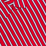 A close-up of the Dimitra Oversized High Low Button Down Shirt by ALICE + OLIVIA in red with vertical white and blue stripes; the top button is fastened, and part of the clothing label appears at the upper left.