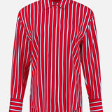 The Dimitra Oversized High Low Button Down Shirt by ALICE + OLIVIA features vertical red, white, and blue stripes, a collar, striped cuffs, and long sleeves. The lightweight silky shirt is shown on a plain white background.