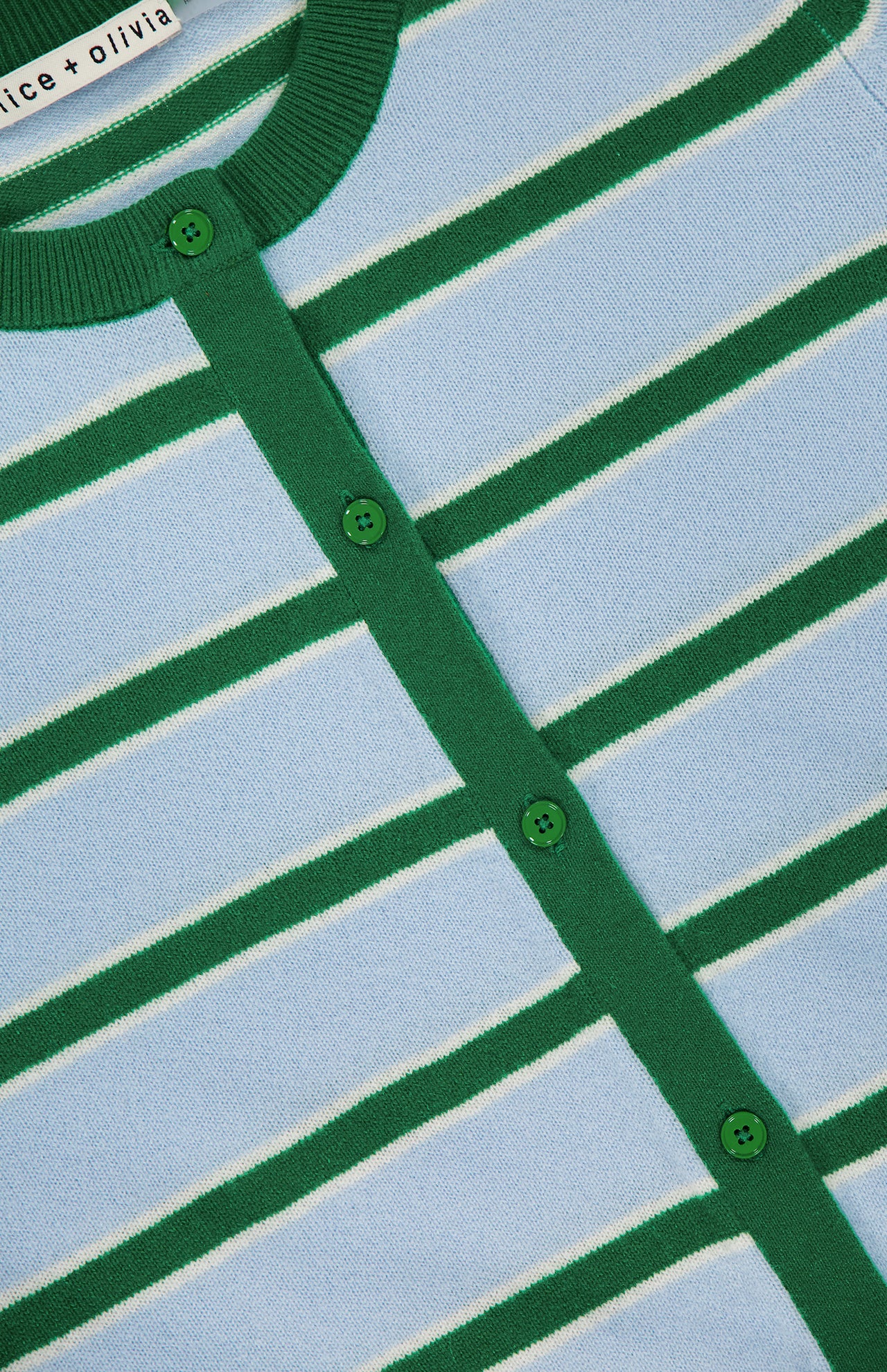 Close-up of the Dollie Striped and Cropped Cardigan by ALICE + OLIVIA, featuring light blue with green and white horizontal stripes, green buttons, and green trim on the button line and collar. The brand label appears at the collar.