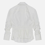 The Edle Gathered Corset Button Down Top by ALICE + OLIVIA is an off-white long-sleeve blouse, featuring gathered sleeves, a wide structured waist inspired by corset detailing, and a ruffled hem. The top is displayed flat against a light gray background, shown from the back.