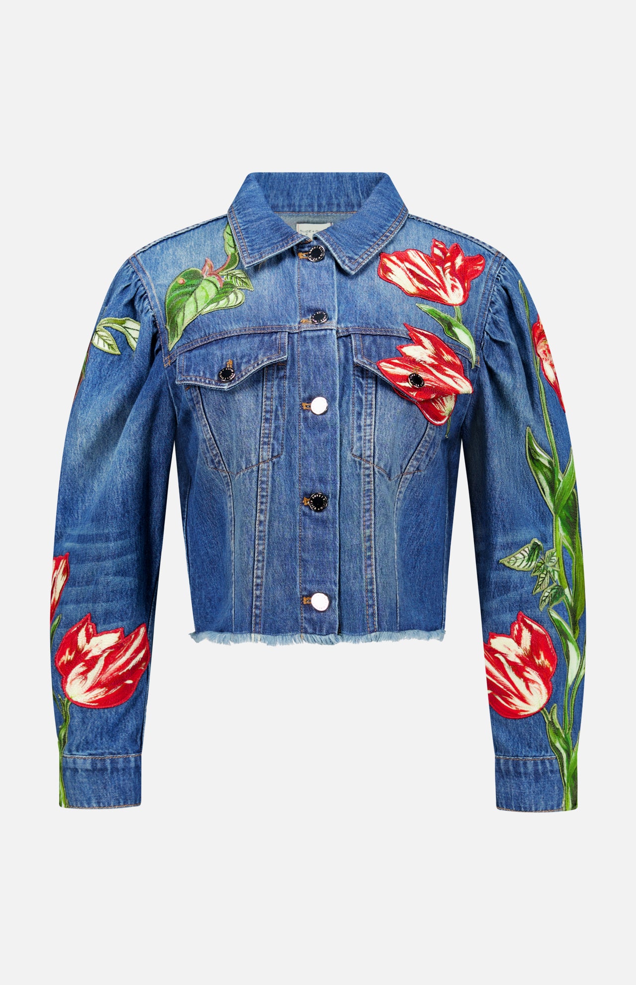 The Elijah Embellished Applique Cropped Denim Jacket by ALICE + OLIVIA is a blue cropped denim jacket with silver buttons, featuring a cropped silhouette and vivid red and white tulip flower embroidered floral appliques on the front, sleeves, and left shoulder.