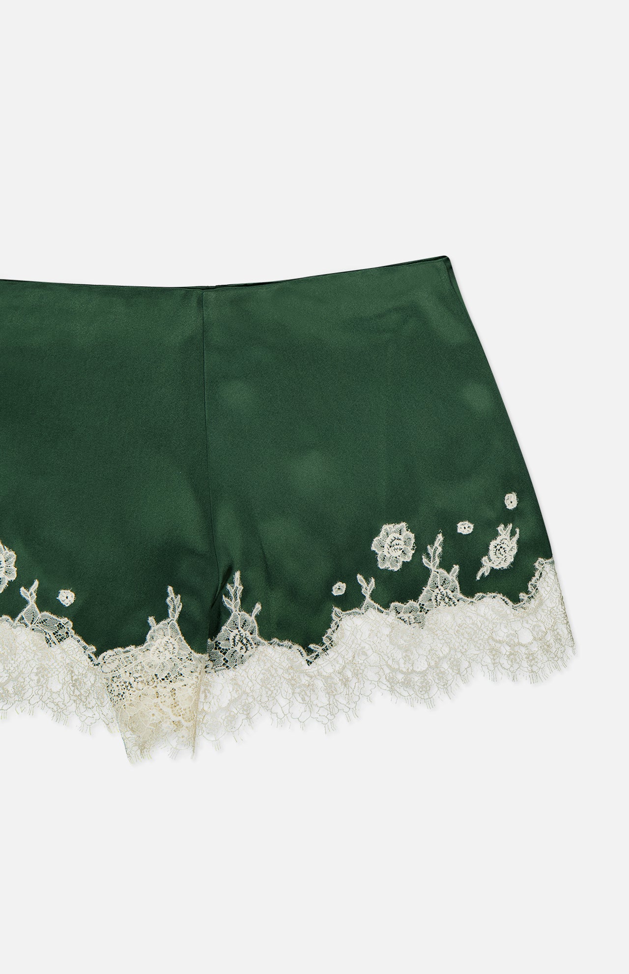 The Elissa Cutaway Lace Short by ALICE + OLIVIA features dark green satin with a smooth, shiny finish, detailed with white lace trim and delicate embroidered florals along the hem—offering a chic summer-in-the-Hamptons vibe.