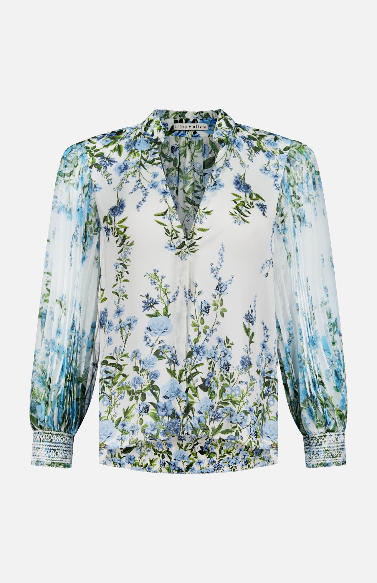 The ALICE + OLIVIA Ilan Pleated Blouson Sleeve Button Front Blouse features a white base with blue and green floral print, pleated sleeves, patterned cuff trim, V-neckline, and relaxed fit for effortless elegance.