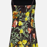 The Julia Scoop Neck Mini Dress by ALICE + OLIVIA is a sleeveless black mini dress with thin shoulder straps, adorned with a vibrant floral print in yellow, red, and orange flowers with green leaves.