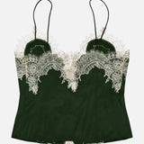 The Julietta Button Front Cutaway Lace Slip Top by ALICE + OLIVIA features a dark green hue with thin shoulder straps and delicate cream lace trim along the neckline and top edge, shown against a white background. This lingerie-inspired piece brings an elegant touch to any wardrobe.