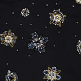 Close-up of the ALICE + OLIVIA Micah Embellished Muscle T-shirt in black, adorned with detailed gold, silver, and blue beaded floral patterns, featuring sparkling beads, sequins, and crystal accents.