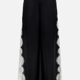 Olivia Pant with Cutaway Lace Godet by ALICE + OLIVIA: wide-leg black trousers with a high waist, belt loops, and cutwork lace trim down each outer side, shown on a plain white background.