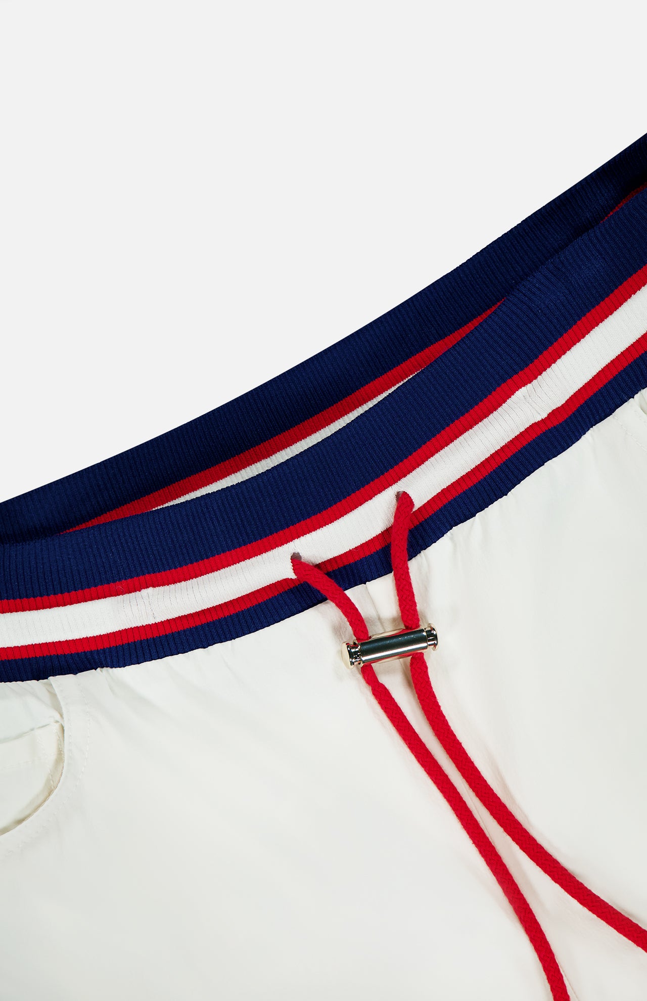Close-up of the ALICE + OLIVIA Olympia Mr Baggy Cargo Pant With Side Stripe, featuring a blue, red, and white striped elastic waistband with red drawstrings and a silver metal clasp.