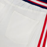 Close-up of the Olympia Mr Baggy Cargo Pant With Side Stripe by ALICE + OLIVIA, featuring wide legs, a sporty back pocket, flap pocket with metallic snap button, red and white side stripes, and a tricolor elastic waistband.
