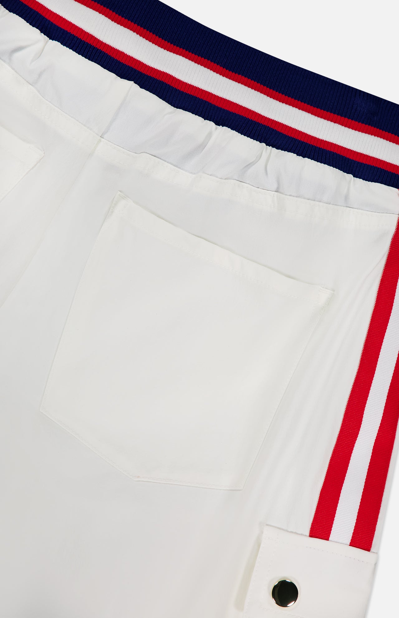 Close-up of the Olympia Mr Baggy Cargo Pant With Side Stripe by ALICE + OLIVIA, featuring wide legs, a sporty back pocket, flap pocket with metallic snap button, red and white side stripes, and a tricolor elastic waistband.