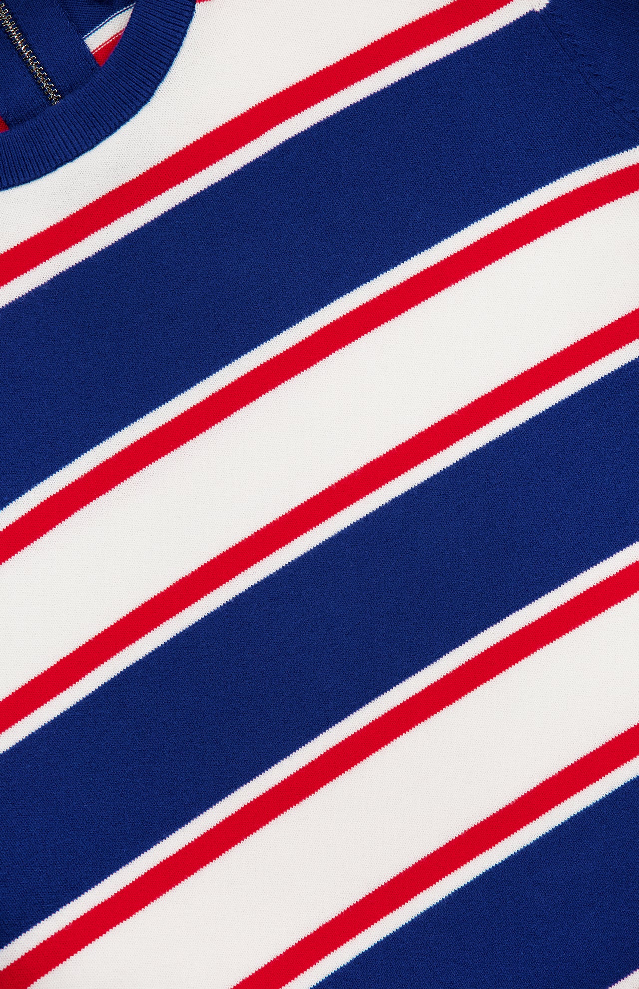 Close-up of the ALICE + OLIVIA Poria Removable Cuffs and Collar Sweater, featuring horizontal blue, white, and red stripes. Thick blue stripes alternate with thin red lines and white spaces; a partial blue ribbed collar is visible at the top left.