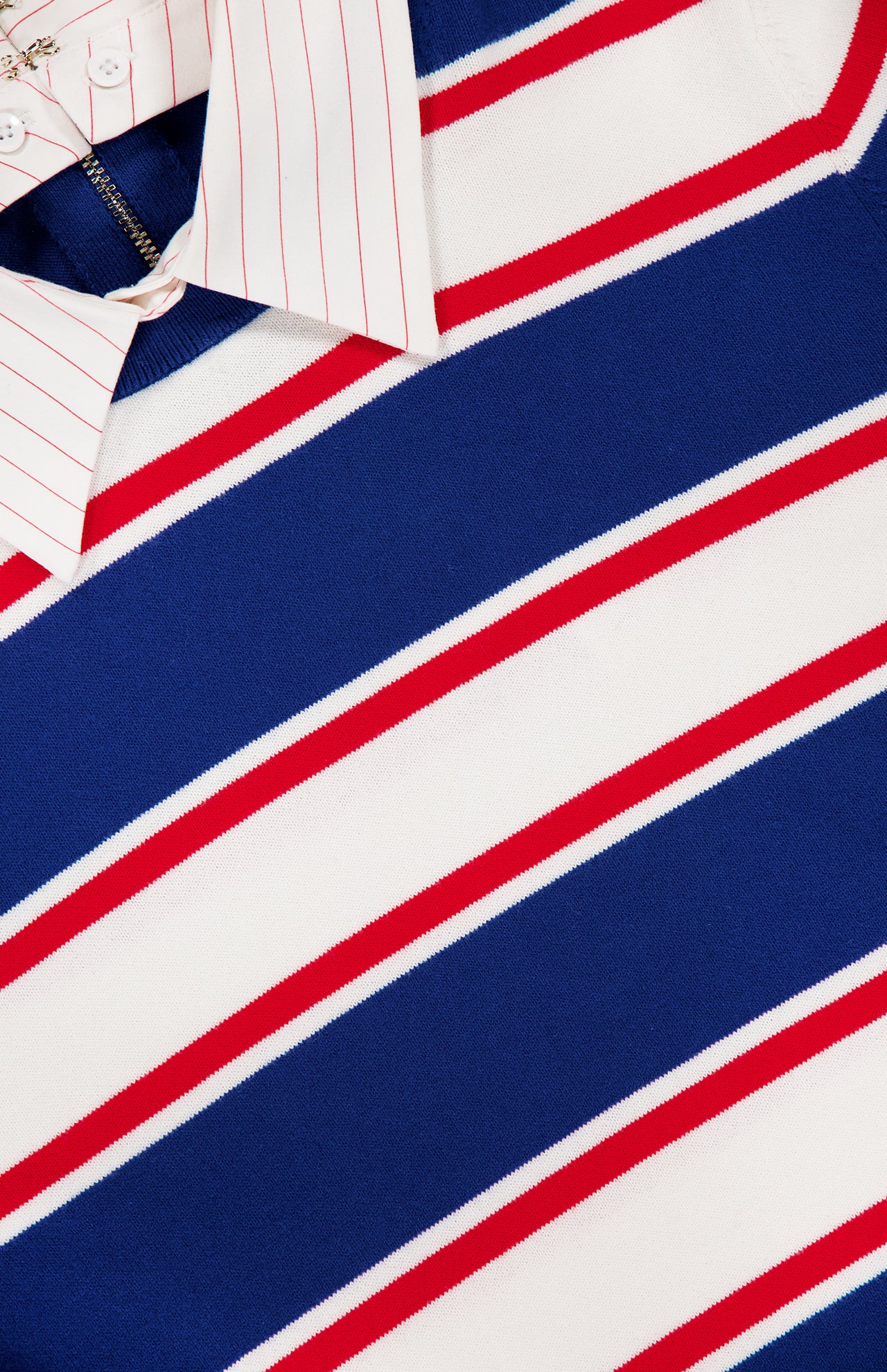 A close-up of the ALICE + OLIVIA Poria Removable Cuffs and Collar Sweater in blue, white, and red stripes, layered over a white shirt with thin red stripes; only the detachable collar and part of the shirt are visible above the sweater.