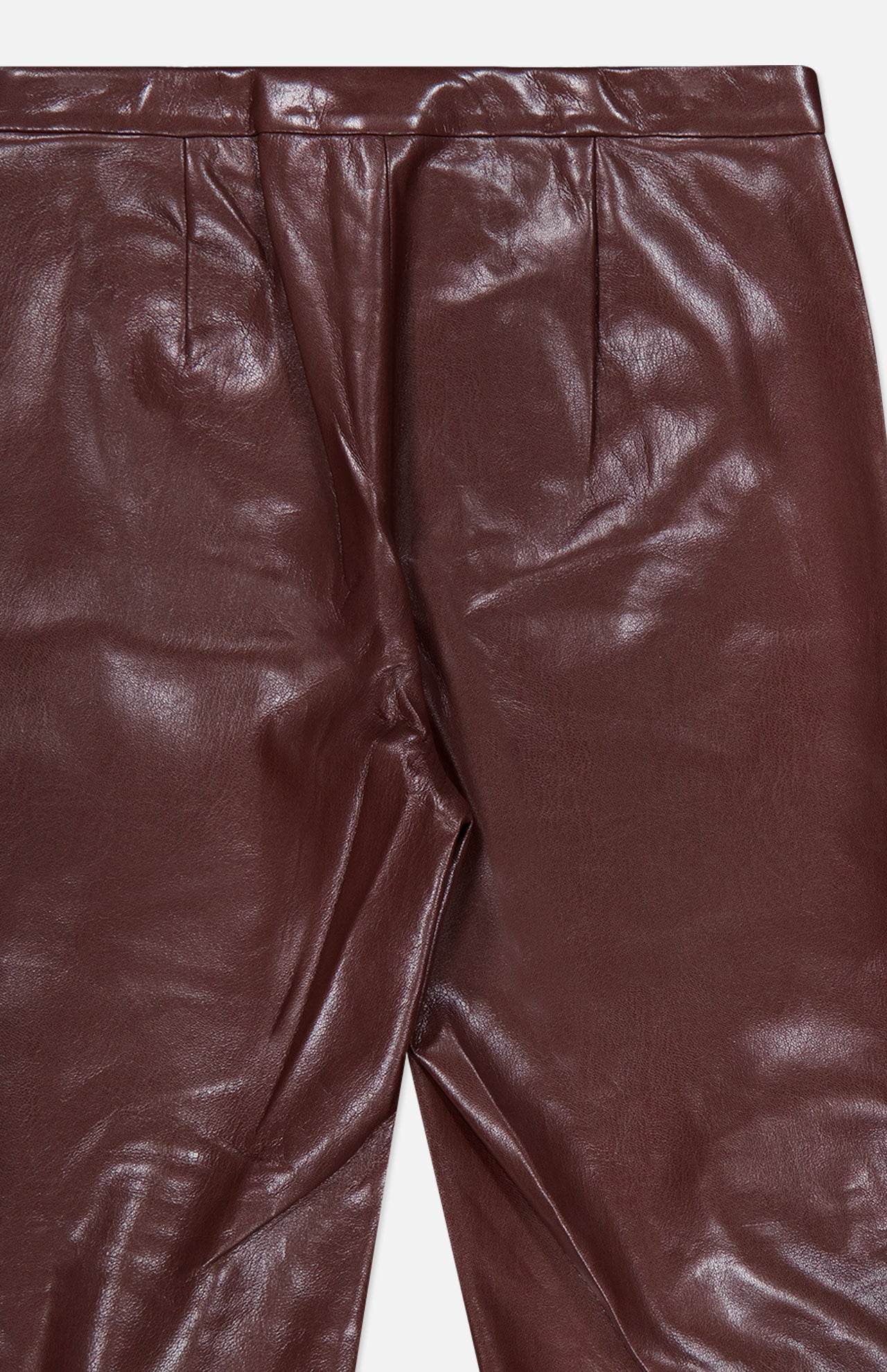 A close-up of the ALICE + OLIVIA Ravyn Vegan Leather Lace Up Bootcut Pant in shiny maroon, featuring low-rise styling and pleats at the waist to highlight the rich texture and vegan leather material.