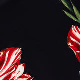 Introducing the Rita Off The Shoulder Draped Top with Scarf by ALICE + OLIVIA—a black, cropped off-the-shoulder piece crafted from luxurious floral silk charmeuse, adorned with sophisticated red and white flowers and green leaf accents along the edges.