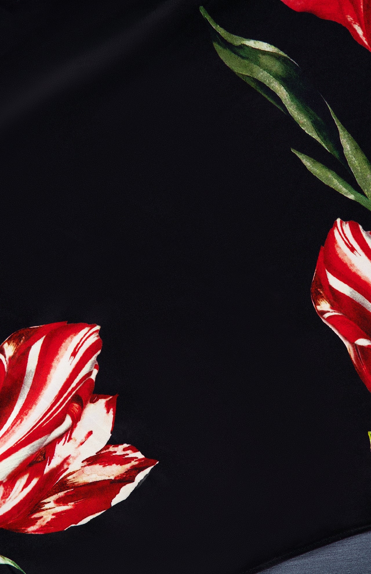 Introducing the Rita Off The Shoulder Draped Top with Scarf by ALICE + OLIVIA—a black, cropped off-the-shoulder piece crafted from luxurious floral silk charmeuse, adorned with sophisticated red and white flowers and green leaf accents along the edges.
