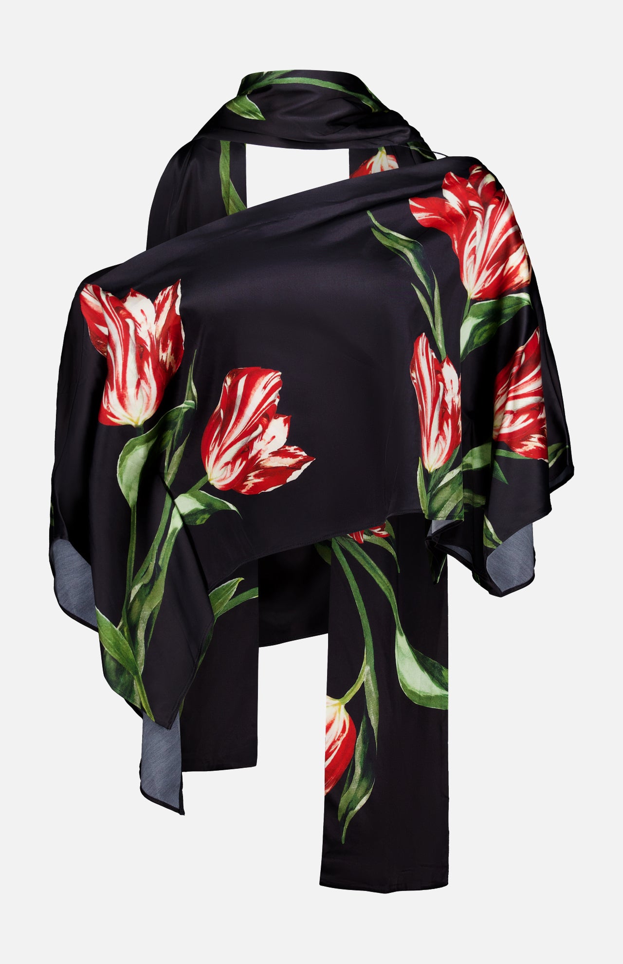 The Rita Off The Shoulder Draped Top with Scarf by ALICE + OLIVIA pairs a cropped black off-the-shoulder top with a luxe black silk charmeuse scarf adorned with bold red and white tulip prints and green leaves, artfully draped to highlight the striking floral pattern.